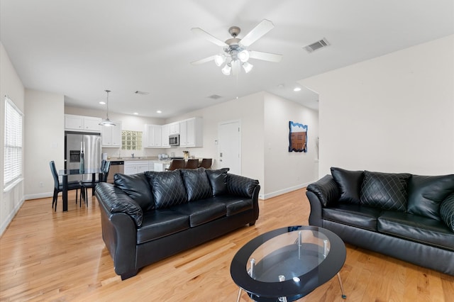 3736 Main Poplar Dr, Houston, TX 77025 - living room with light wood-style floors, ceiling fan, and recessed lighting