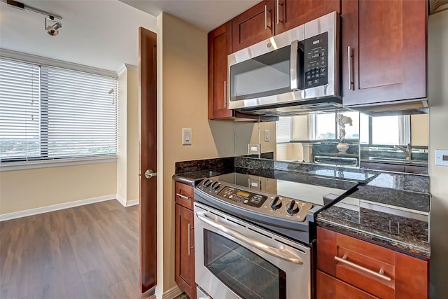 3525 Sage Rd Unit 1703, Houston, TX 77056 - kitchen featuring appliances with stainless steel finishes, wood finished floors, healthy amount of natural light, and dark stone counters