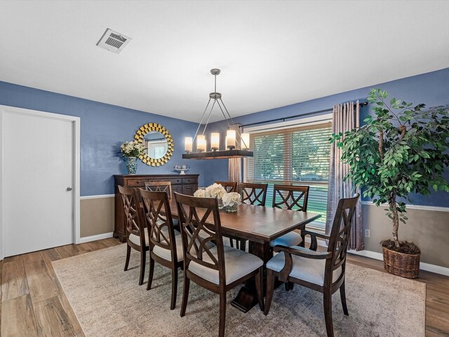 4710 Mckeever Ln, Missouri City, TX 77459 - dining room featuring wood finished floors, a chandelier, and wainscoting