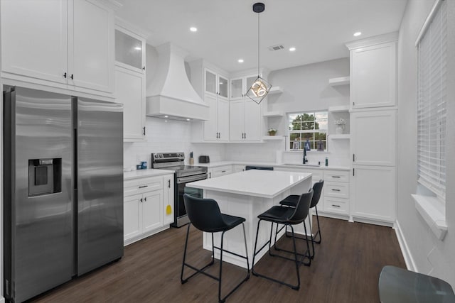 25446 Morgan Cemetery Rd, Cleveland, TX 77328 - kitchen featuring stainless steel appliances, premium range hood, open shelves, white cabinets, and a kitchen breakfast bar