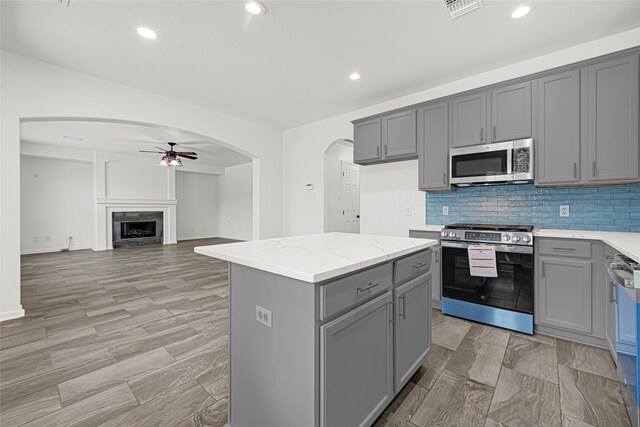 7823 Autumn Hollow Ln, Houston, TX 77041 - kitchen featuring stainless steel appliances, gray cabinets, ceiling fan, arched walkways, and recessed lighting