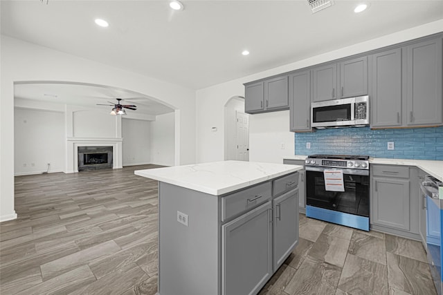 7823 Autumn Hollow Ln, Houston, TX 77041 - kitchen featuring stainless steel appliances, gray cabinets, ceiling fan, arched walkways, and recessed lighting