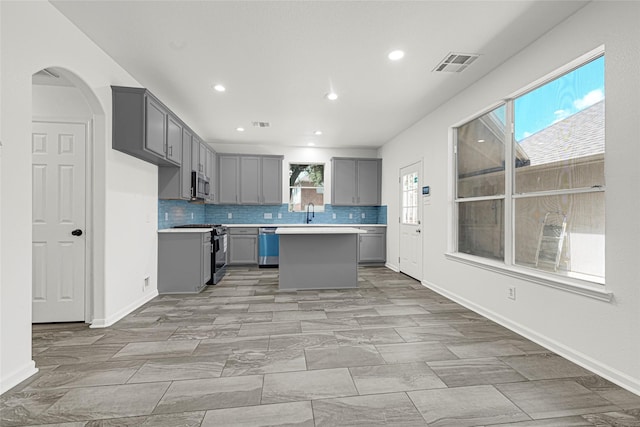 7823 Autumn Hollow Ln, Houston, TX 77041 - kitchen with gray cabinetry, stainless steel appliances, tasteful backsplash, a center island, and light countertops