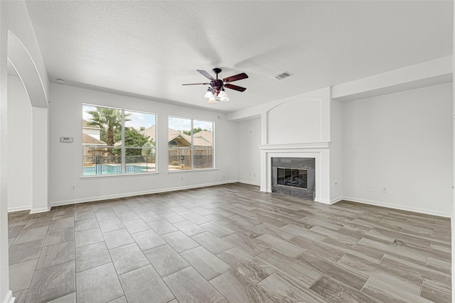 7823 Autumn Hollow Ln, Houston, TX 77041 - unfurnished living room with a ceiling fan, a tiled fireplace, and a textured ceiling