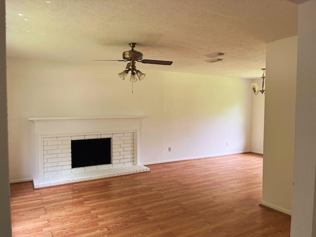 12138 Flaxen Dr, Houston, TX 77065 - unfurnished living room with wood finished floors, a textured ceiling, a ceiling fan, and a fireplace