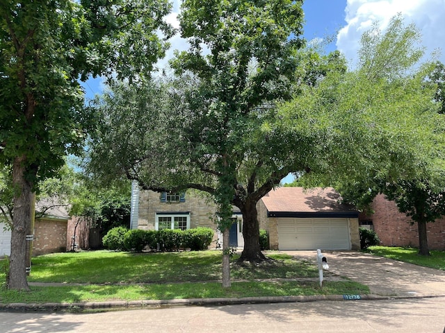 12138 Flaxen Dr, Houston, TX 77065 - view of property hidden behind natural elements featuring driveway, brick siding, a front yard, and an attached garage