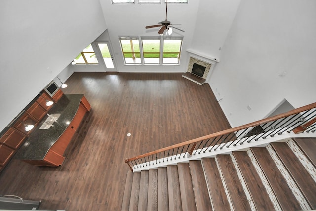 4330 Lasker Brook Ct, Katy, TX 77494 - unfurnished living room with ceiling fan, wood finished floors, a fireplace with raised hearth, stairs, and high vaulted ceiling