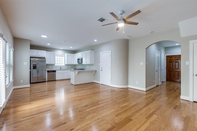 8765 Bryam, Houston, TX 77061 - unfurnished living room with arched walkways, light wood-style flooring, ceiling fan, and recessed lighting