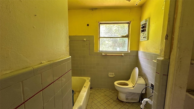 7218 Bretshire Dr, Houston, TX 77016 - bathroom featuring tile walls, tile patterned flooring, a wainscoted wall, and a bath