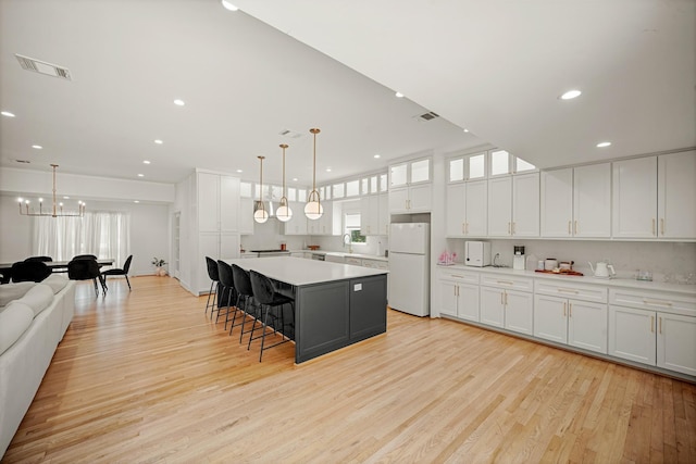 5630 Lymbar Dr, Houston, TX 77096 - kitchen featuring freestanding refrigerator, light wood-type flooring, light countertops, a spacious island, and recessed lighting