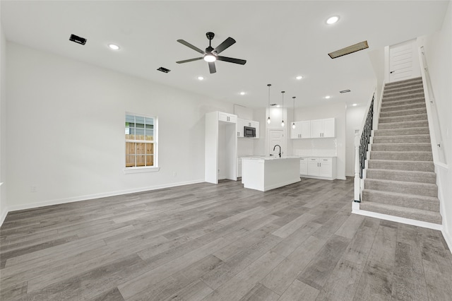 7922 Sealey St, Houston, TX 77088 - unfurnished living room with ceiling fan, stairway, wood finished floors, and recessed lighting