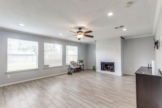 3038 Rainmont Ln, Katy, TX 77449 - living area featuring ornamental molding, ceiling fan, a tiled fireplace, light wood-type flooring, and recessed lighting