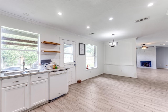 3038 Rainmont Ln, Katy, TX 77449 - kitchen featuring white dishwasher, ornamental molding, recessed lighting, open floor plan, and a large fireplace
