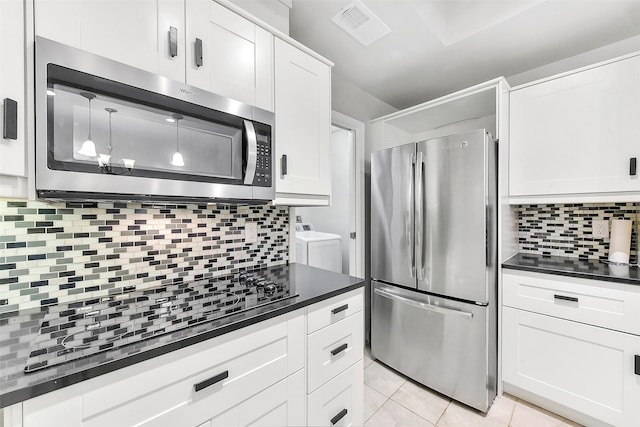 169 Litchfield Ln, Houston, TX 77024 - kitchen featuring appliances with stainless steel finishes, tasteful backsplash, dark countertops, and white cabinetry