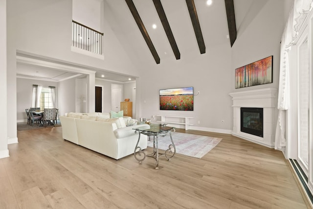6919 Shoreline View Dr, Katy, TX 77493 - living area featuring high vaulted ceiling, light wood finished floors, beamed ceiling, a glass covered fireplace, and recessed lighting