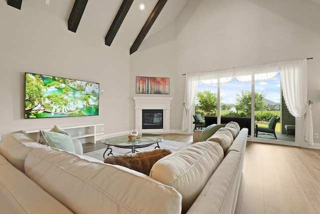 6919 Shoreline View Dr, Katy, TX 77493 - living room featuring high vaulted ceiling, beamed ceiling, a glass covered fireplace, light wood finished floors, and recessed lighting