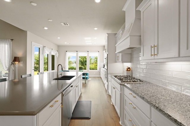 6919 Shoreline View Dr, Katy, TX 77493 - kitchen with appliances with stainless steel finishes, a large island, light wood-style flooring, tasteful backsplash, and recessed lighting