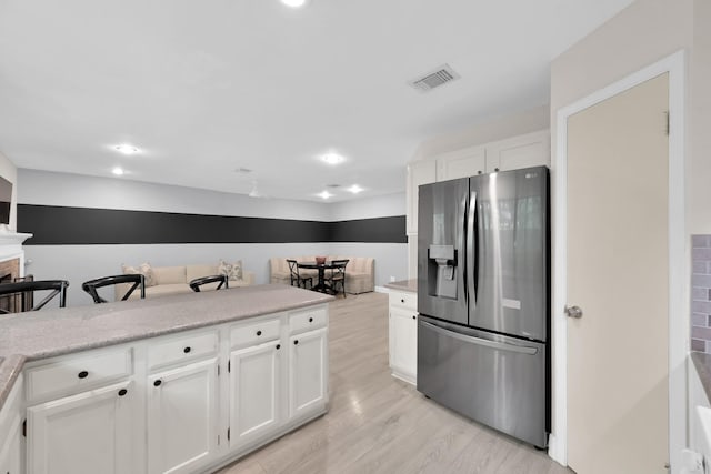 58 Sandpebble Dr, Spring, TX 77381 - kitchen featuring stainless steel refrigerator with ice dispenser, light wood finished floors, white cabinets, light countertops, and recessed lighting