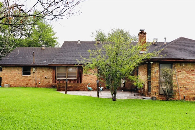 1108 Easy St, Rosenberg, TX 77471 - rear view of house with brick siding, a patio area, a yard, and a chimney