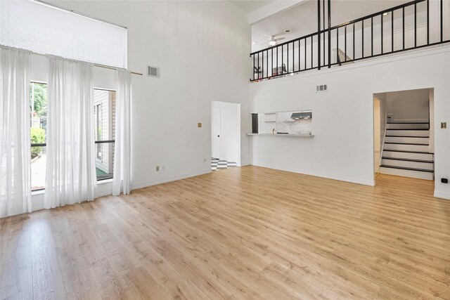 8033 Oakwood Forest Dr, Houston, TX 77040 - unfurnished living room featuring a high ceiling, stairway, wood finished floors, and ceiling fan