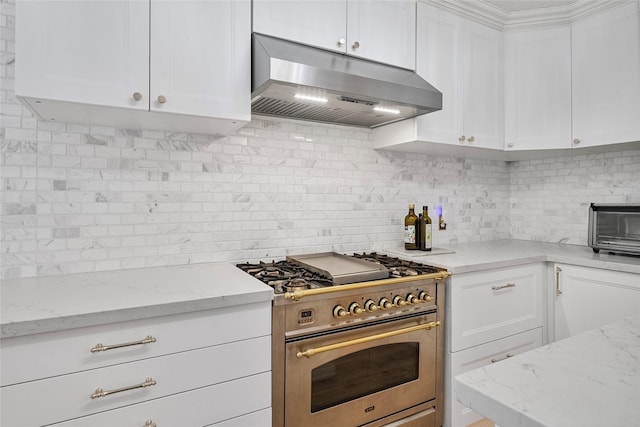 8033 Oakwood Forest Dr, Houston, TX 77040 - kitchen with under cabinet range hood, high end range, decorative backsplash, and white cabinets