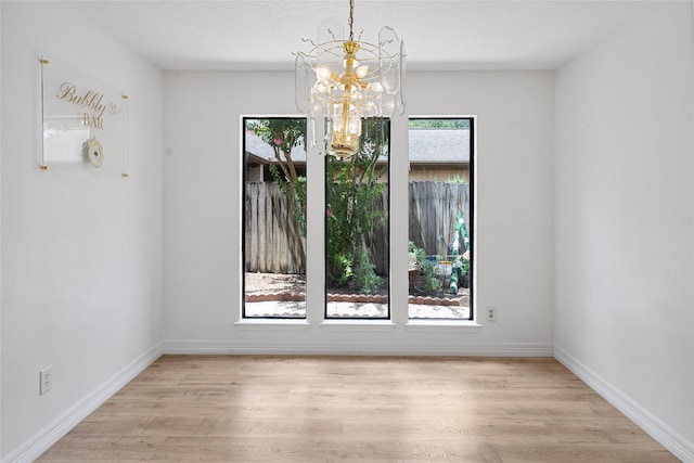 8033 Oakwood Forest Dr, Houston, TX 77040 - unfurnished dining area with a chandelier and light wood finished floors