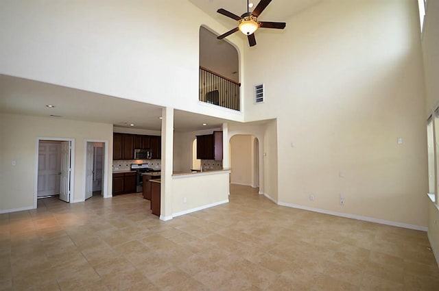 4202 Misty Waters Ln, Katy, TX 77494 - unfurnished living room featuring a ceiling fan, arched walkways, and a towering ceiling