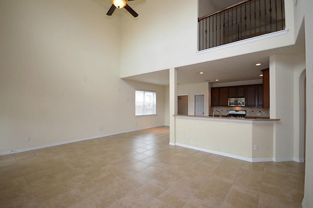 4202 Misty Waters Ln, Katy, TX 77494 - unfurnished living room with ceiling fan, a high ceiling, light tile patterned floors, and recessed lighting
