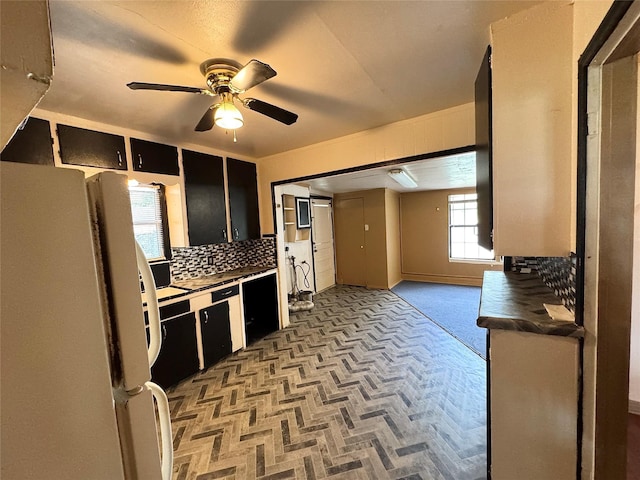 2066 Earl St, Beaumont, TX 77703 - kitchen with freestanding refrigerator, ceiling fan, dark cabinetry, and backsplash