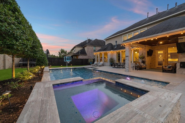 5119 Kendalia Cloud Ln, Fulshear, TX 77441 - pool at dusk with an in-ground hot tub, a fenced backyard, and a patio