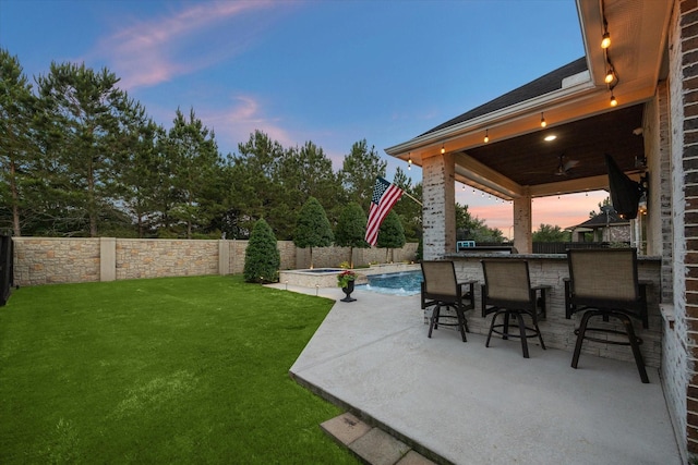 5119 Kendalia Cloud Ln, Fulshear, TX 77441 - yard at dusk with a fenced backyard, a patio, and a pool with connected hot tub