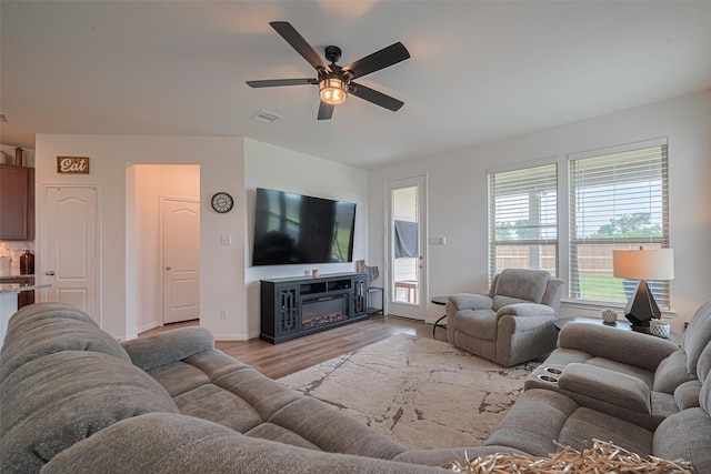 7227 Birchville Dr, Rosharon, TX 77583 - living room with a ceiling fan, light wood-style floors, and a glass covered fireplace