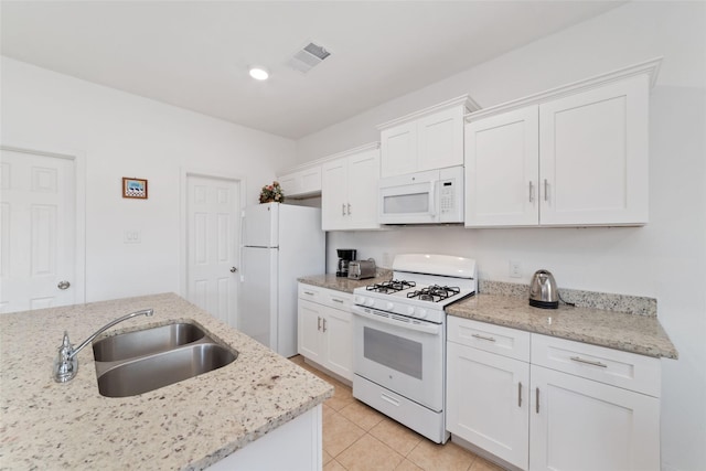 12712 Plummersville St, Houston, TX 77072 - kitchen featuring white appliances, white cabinetry, light tile patterned floors, and light stone countertops