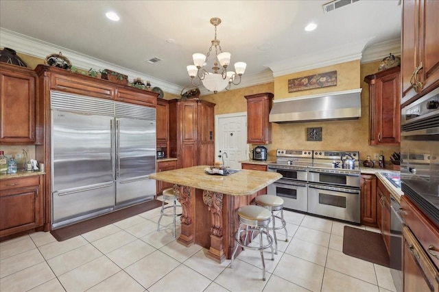 7510 Shadow Creek Dr, Beaumont, TX 77707 - kitchen featuring appliances with stainless steel finishes, a breakfast bar area, a chandelier, crown molding, and light tile patterned floors