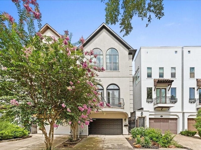 405 Reinerman St, Houston, TX 77007 - view of property featuring concrete driveway, an attached garage, and stucco siding