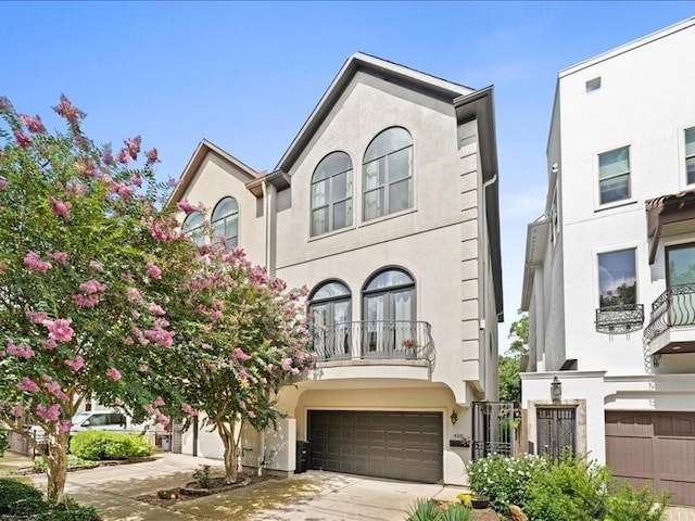 405 Reinerman St, Houston, TX 77007 - view of property featuring stucco siding, concrete driveway, and a garage