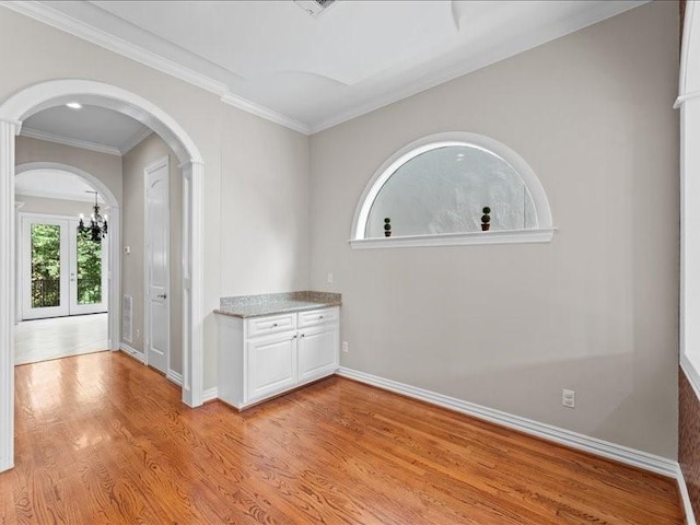 405 Reinerman St, Houston, TX 77007 - unfurnished room with light wood finished floors, arched walkways, a chandelier, and crown molding