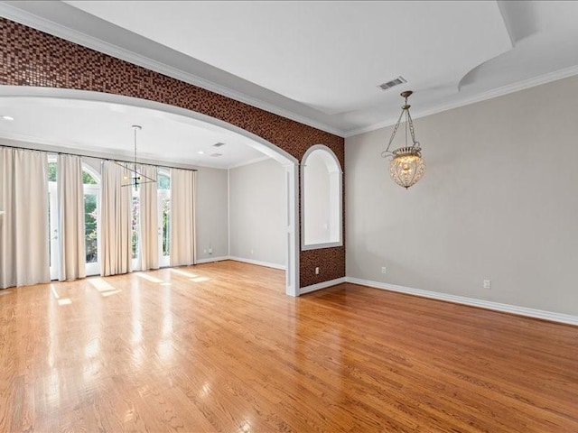 405 Reinerman St, Houston, TX 77007 - unfurnished room with a chandelier, light wood finished floors, arched walkways, and ornamental molding