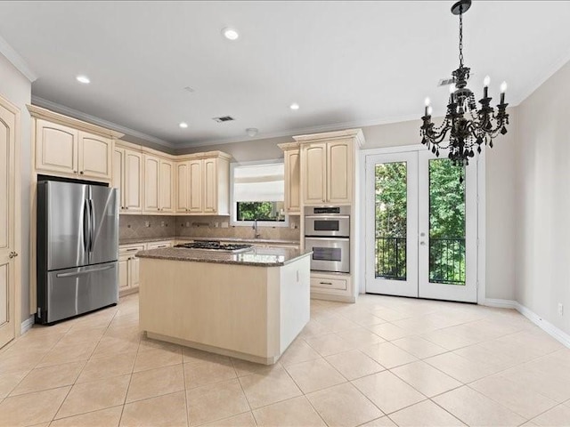 405 Reinerman St, Houston, TX 77007 - kitchen featuring appliances with stainless steel finishes, cream cabinetry, ornamental molding, tasteful backsplash, and light tile patterned flooring