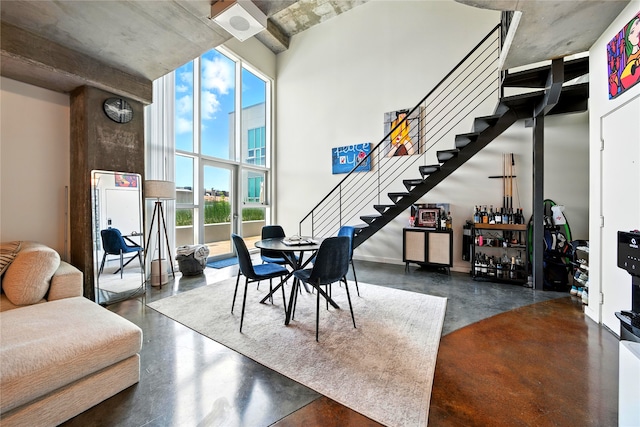 2000 Bagby St Unit 5423, Houston, TX 77002 - living room featuring concrete flooring, stairway, a high ceiling, and a bar