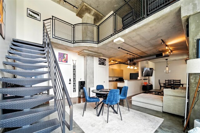 2000 Bagby St Unit 5423, Houston, TX 77002 - dining area featuring track lighting, finished concrete flooring, stairs, and a towering ceiling