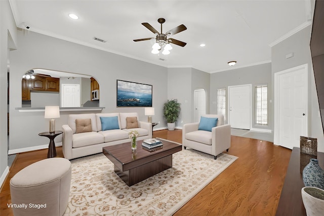 13314 Kaylee Ln, Santa Fe, TX 77510 - living area with ceiling fan, arched walkways, wood finished floors, ornamental molding, and recessed lighting