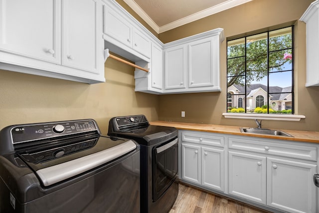 13722 Vinery Ln, Cypress, TX 77429 - laundry room with washing machine and dryer, cabinet space, ornamental molding, and wood finished floors