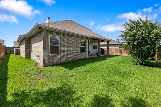 2619 Portland Ave, College Station, TX 77845 - back of house with brick siding, a fenced backyard, a chimney, and roof with shingles