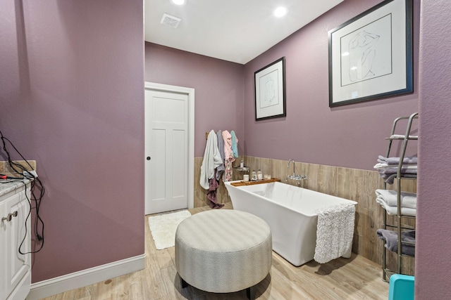 2619 Portland Ave, College Station, TX 77845 - bathroom with a freestanding tub and wood finished floors