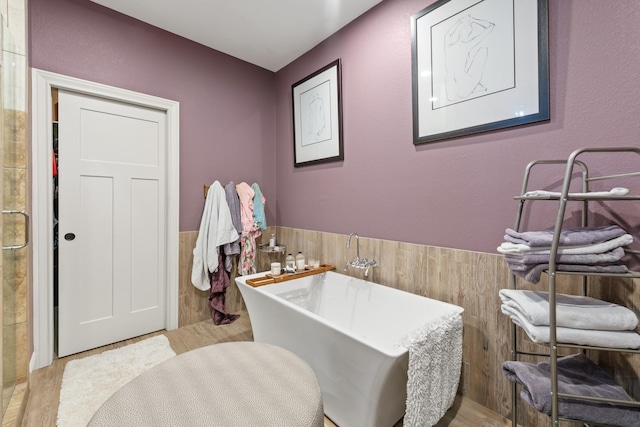 2619 Portland Ave, College Station, TX 77845 - full bathroom featuring a soaking tub, wainscoting, wood finished floors, and tile walls
