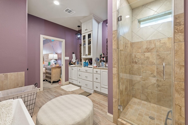 2619 Portland Ave, College Station, TX 77845 - full bathroom featuring a stall shower, wood finished floors, and vanity