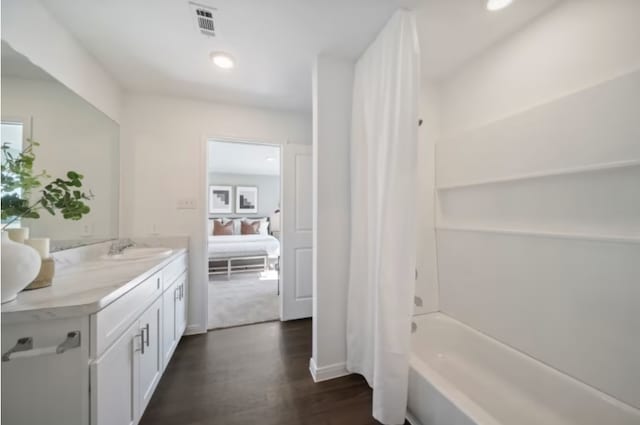 16424 Windy Cove Ct, Conroe, TX 77378 - bathroom featuring vanity, connected bathroom, wood finished floors, shower / bath combo with shower curtain, and recessed lighting