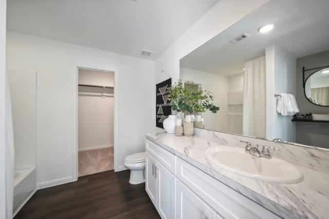 16424 Windy Cove Ct, Conroe, TX 77378 - bathroom with wood finished floors, vanity, a walk in closet, and a bathtub
