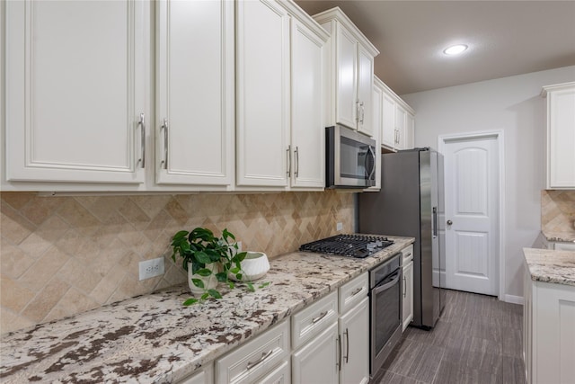 18723 Pilot Knolls Dr, Cypress, TX 77433 - kitchen with stainless steel appliances, white cabinets, tasteful backsplash, light stone counters, and recessed lighting